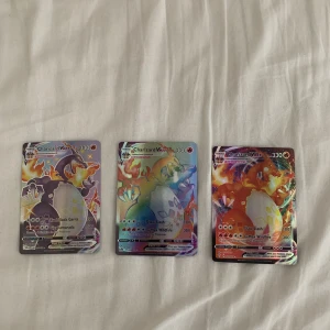 Charizard VMAX Pokémonkort (3 st) - Tre exklusiva Charizard VMAX Pokémonkort med färgstark och glittrig design. Perfekt för samlare och fans som vill boosta sin samling med några av de mest ikoniska och eftertraktade korten. Korten är i fint skick och redo för nya äventyr!
