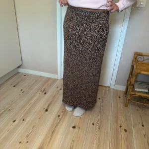 Leopardmönstrad långkjol från KappAhl - Snygg långkjol från KappAhl med leopardmönster i brunt och svart. Kjolen har en rak passform och slits på sidan för extra vibe.