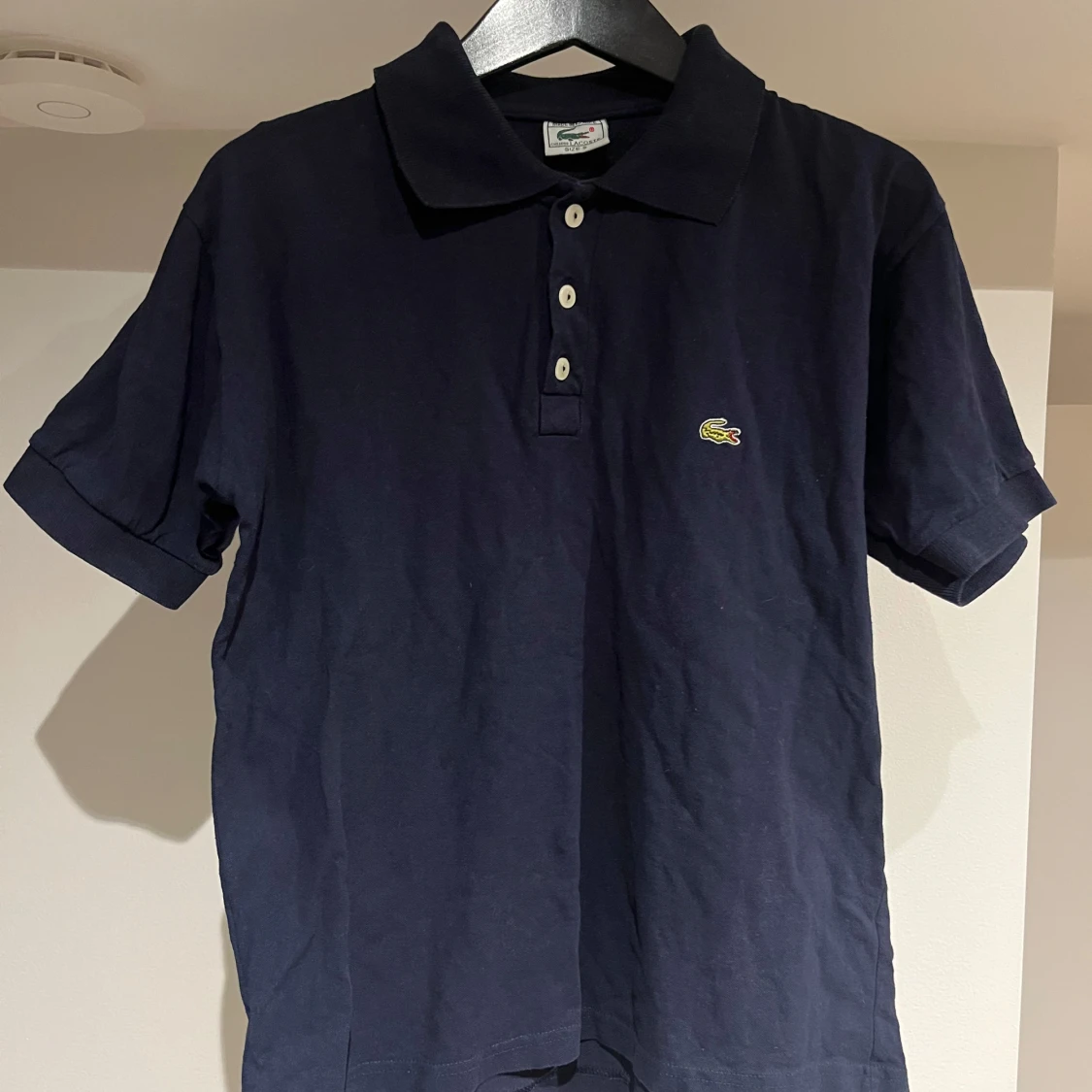 Mörkblå pikétröja från Lacoste