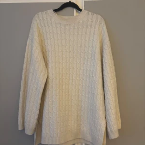 Beige kabelstickad tröja BikBok XS - Kabelstickad beige tröja från BikBok i storlek XS. Tröjan har rund halsringning, lång ärm och en loose fit. Perfekt för lager-på-lager och chill höst- eller vinterstil. Mjuk och skön känsla med klassiskt stickat mönster.