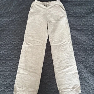 Beiga linnebyxor från Kappahl, stl 152 - Snygga beiga linnebyxor från Kappahl i storlek 152. Byxorna har raka ben, resår i midjan och sidfickor. Perfekta för en chill och avslappnad stil under varma dagar.