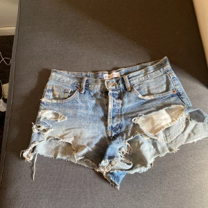 Blå  jeansshorts från Zara - Snygga blå jeansshorts från Zara, ganska slitna. De har hål under högra fickan dock syns det inte när man har på sig de. 