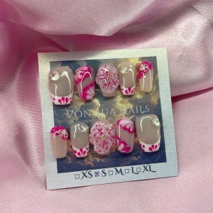 PinkFluer (S);Short Coffin - Snygga handgjorda press-on naglar i nude och rosa med coola swirl-mönster, 3D-blommor och silvriga dekorationer. Mix av fransk tipp, trendig blom-effekt och detaljer i vitt och fuchsia. Perfekt för dig som vill sticka ut med unika naglar! I storlek S: 15 mm, 11,5 mm, 12 mm, 11 mm, 9 mm 