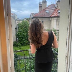 Svart omlottopp med snörning - Supersnygg svart topp med djup v-ringning och knyt framtill. 