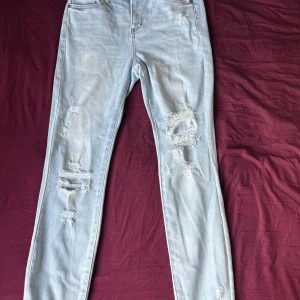Ljusblå ripped skinny jeans - Snygga ljusblå skinny jeans med slitna detaljer och hål på benen. Jeansen har klassisk femficksdesign och är tillverkade i stretchigt denim för en bekväm passform. Perfekta för en avslappnad och trendig look.