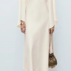 Elegant vit satin-klänning från Mango  - Säljer min vita studentklänning i satin från Mango med vida, långa ärmar och minimalistisk design. Klänningen har en mjuk, flytande siluett och känns lyxig och stilren. Använd endast en gång på studenten. Fläck och hålfri, i nyskick.