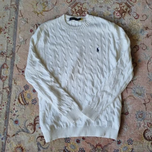 RALPH LAUREN KABELSTICKAD TRÖJA- vit - Säljer denna riktigt snygga kabelstickade tröjan från Ralph Lauren i storlek L. Kontakta vid intresse. 