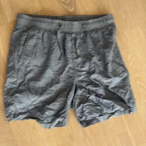 Grå shorts från Jack & Jones - Snygga grå shorts från Jack & Jones med elastisk midja och snörning. De har en avslappnad passform, sidofickor och en bakficka med diskret logotyp. Perfekta för varma dagar och chill stunder. Materialet känns lätt och luftigt.