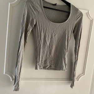 Ljusgrön långärmad topp - En enkel och stilren ljusgrön långärmad topp med rundad urringning. Perfekt att matcha med jeans eller kjol för en clean look. Tunn och mjuk i materialet, sitter snyggt och är lätt att bära till olika outfits.