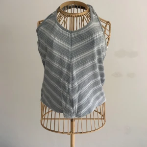 Randig grå/vit linnetopp från Lindex - Snygg grå och vit randig linnetopp från Lindex med halterneck och ärmlös design. Toppen har en mjuk och bekväm känsla, perfekt för varma dagar. Den har en lätt croppad passform och tunna ränder som ger en fräsch look. Liten i storleken, passar L bäst, den är dock väldigt töjbar/flexibel.