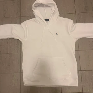 Vit hoodie från Polo Ralph Lauren - Vit hoodie från Polo Ralph Lauren med klassisk huva och snörning.  Storlek L. Använd ett fåtal gånger men har växt ur så därför så billigt pris. Nypris är 1695kr och den är köpt på zalando.