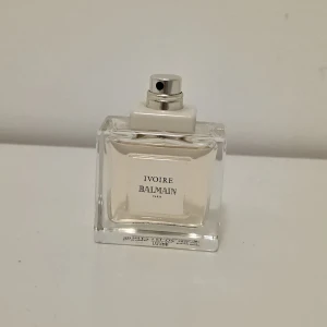 Ivoire Balmain parfym 50ml - Elegant parfym från Balmain, Ivoire, i en stilren och transparent glasflaska med silverfärgad spraykork. Doften är klassisk och tidlös, perfekt för dig som gillar exklusiva och sofistikerade parfymer. Flaskan rymmer 50 ml.
