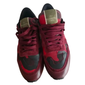 Säljer ett par Valentino Rockrunner sneakers i rött, storlek 42 - Säljer ett par Valentino Rockrunner sneakers i vinrött och svart med röd camouflage-mönster, storlek 42. Använda endast ett par veckor – i princip nya! Inga skador eller större tecken på slitage, sulan och materialet är i toppskick.  Enda anledningen till att jag säljer är att jag fått andra sneakers i present som jag använder mer, så de här har blivit stående.  Nypris ligger runt 1318, så detta är ett riktigt bra fynd. Tveka inte att höra av dig vid frågor!!