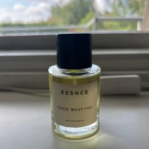 ESSNCE Coco 'Bout You parfym - Fräsch parfym från ESSNCE med namnet Coco 'Bout You. Flaskan är rund och genomskinlig med svart lock och vit etikett. Innehållet är ljusgult och det är en Eau de Parfum som känns modern och stilren. Doft av kokos och ananas. Säljer pågrund av att den ej används.