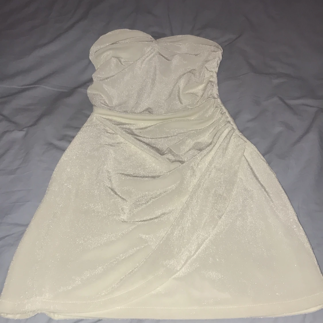 Glittrig vit axelbandslös klänning BikBok