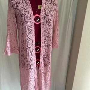 Ny spetstunika från Lindex, med prislapp kvar - Superfin rosa lång tunika från Lindex i spets med trekvartsärmar och utsvängda ärmslut. Klänningen är helt i spets med blommigt mönster och har en rak passform. Perfekt för dig som vill sticka ut med en romantisk vibe.