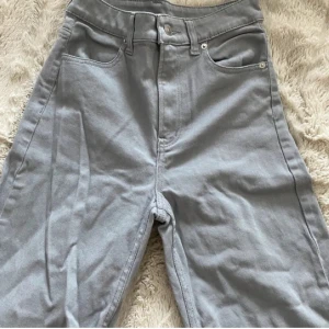 Gråa wide jeans med hög midja - Snygga grå jeans med hög midja och breda ben. Klassisk femficksmodell med raka bakfickor och dragkedja fram. Perfekta för dig som gillar en avslappnad och trendig look. Materialet är mjukt och skönt bomullstyg.