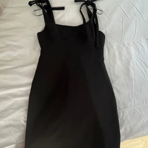 Svart klänning - Svart kort klänning från Zaras rosetter på axlarna, aldrig använd endast testad- säljer då den är för liten och har därför inga bilder med den på!! ❤️❤️Storlek L men passar även för de som brukar ha storlek M!!❤️Så ganska liten i storleken 