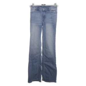 Ljusblå lågmidjade bootcut jeans - Snygga ljusblå  jeans med klassisk bootcut-passform. Jeansen har fem fickor, bälteshällor och dragkedjegylf. Tillverkade i slitstarkt denim som ger en avslappnad och cool vibe. Perfekta för dig som gillar retrostil och vill ha ett par jeans med lite extra vidd nertill.