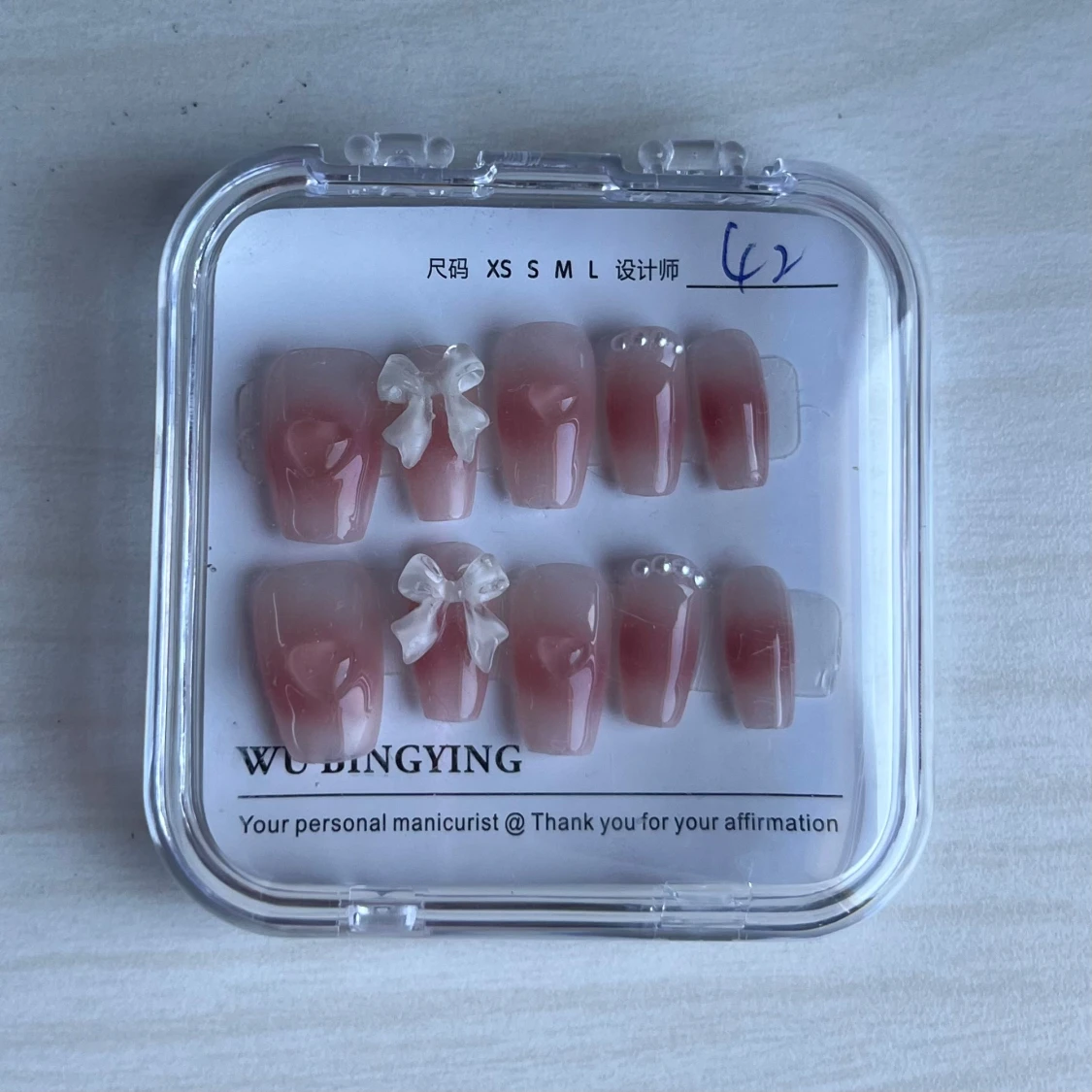 Rosa press on naglar med rosetter och pärlor