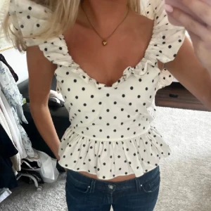 vit prickig blus  - supersöt vit prickig blus med volang och öppen rygg🤍de två första bilderna är lånade!💓
