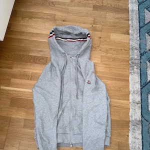 Grå Moncler zip up hoodie - Nädtan aldrig använd i väldig bra kondition. Perfekt för hösten