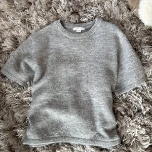 grå stickad kortärmad tröja - mysig grå stickad tröja från Gina Tricot med korta ärmar och rund halsringning, enkel att matcha med både jeans och kjol!! endast testad, köpt för 200kr💗