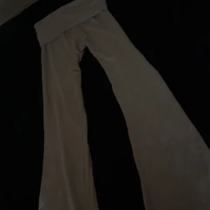 Grå flare leggings (Gina Tricot XXS) - Gråa mjukisbyxor från Gina Tricot i storlek XXS. Byxorna har hög midja med bred linning och vida ben för en chill och avslappnad look. Perfekta för dig som gillar bekväma och snygga basplagg.