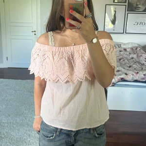 Ljusrosa offshoulder topp💞 - Superfin ljusrosa offshoulder topp från Gina Tricot med broderad volang upptill. Toppen har en romantisk känsla med snygga hålbroderier och elastisk kant som håller den på plats. Perfekt till jeans eller kjol för en söt look.💕Toppen är köpt begagnad men har inga defekter 