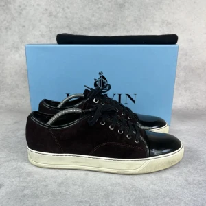 Lanvin DBB1 cap toe sneaker - – Condition: 8/10 - replaced inner soles  - Size: 42/UK8  – What is included: Dustbag  – Retail price: 5000 + SEK  Please note that Lanvins fit big and our recommendation is to go one size down