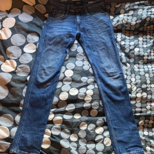 Replay Anbass slim fit jeans blå - Säljer ett par Replay Anbass slim fit jeans i klassisk blå denim. Jeansen har fem fickor, snygga kontrastsömmar och Replay-logga på bakfickan. De är tillverkade i bomull och har en smal passform som sitter snyggt längs benen. Pris går att diskutera 
