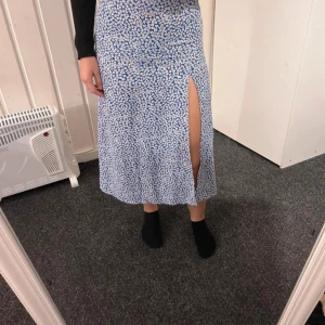 långkjol - Blommig långkjol i blått med vitt blommönster med slits framtill. Kjolen är ifrån shein är använd men i bra skick
