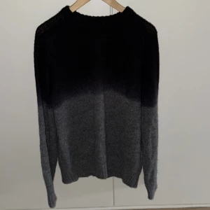 Svart-grå stickad tröja Mads Nørgaard - Snygg stickad tröja från Mads Nørgaard i en cool svart och grå färgton med fade-effekt. Tröjan har rund hals och långa ärmar, perfekt för dig som gillar stilrena och mjuka plagg. Passar dig som vill ha en chill och trendig look. Nypris 1500 kr. Plagget är i alpackaulll och är i mycket bra skick.