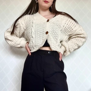 Stickad kofta med knappar - Superfin vit-beige stickad kofta med grovt kabelstickat mönster och stora bruna knappar framtill. Koftan är croppad och har en loose passform med långa ärmar och v-ringad hals🥰