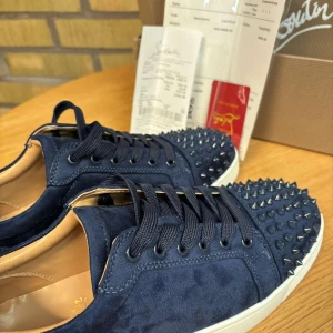 Mörkblå Louboutin sneakers med nitar - Säljer mina mörkblåa sneakers från Christian Louboutin i mocka med svarta nitar på tån. Kvitto finns så det är bara att höra av er. 
