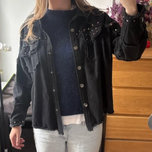 Svart jeansjacka med nitar och råa kanter - Cool svart jeansjacka med nitar