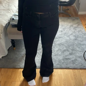 Svarta bootcut jeans från Pieces - Säljer ett par svarta jeans från Pieces med bootcut passform och klassisk femficksdesign. Jeansen har låg midja och är gjorda i mjukt denimtyg med lite stretch. Perfekta för dig som gillar en snygg siluett med lite utsvängda ben.