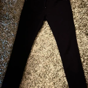 Svarta skinny jeans Replay Luz 28/30 - Svarta skinny jeans från Replay, modell Luz. Snygg passform med smala ben och klassisk femficksdesign. Jeansen är i stretchigt material för extra komfort och har diskreta detaljer. Perfekta för dig som gillar en clean och stilren look.