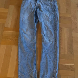 Ljusblå raka jeans från Jack and Jones  - Säljer ett par ljusblå jeans med klassisk rak passform. Byxorna har fem fickor och är tillverkade i mjukt denimtyg som ger en skön känsla. Perfekta för dig som gillar en enkel och tidlös stil. Passar till sneakers eller boots. Storlek 29,32