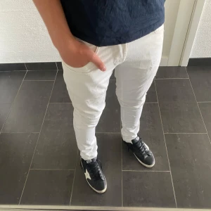 Dondup George  - Säljer ett par vita skinny jeans från dondup i storlek 32. De har klassisk femficksdesign, smal passform och är gjorda i stretchigt jeanstyg för en tajt look. Perfekta för dig som gillar stilrena och fräscha jeans med modern siluett.