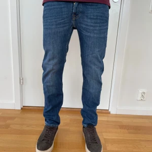 Blå regular fit jeans från Dressmann - Knappt använda blå jeans från Dressmann i regular fit. Jeansen har fem fickor, raka ben och normal midja. Materialet är tåligt denim i bomull och passformen är avslappnad men ändå snygg. Tveka inte att kontakta vid frågor.