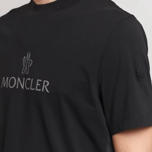 Svart Moncler t-shirt med logga Storlek M men är som L. Helt oanvänd eftersom den är för stor - Svart t-shirt från Moncler med klassisk rund hals och korta ärmar. Stor Moncler-logga i vitt på bröstet och en diskret svart patch med logga på ärmen. Tillverkad i mjuk bomull som känns skön mot huden. Perfekt för dig som gillar stilrena och exklusiva plagg. a-kopi 