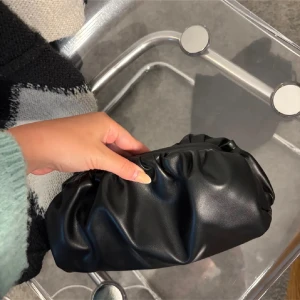 svart clutch väska - Köpt second hand på karla plan loppisen. Jätte snygg band medkommer