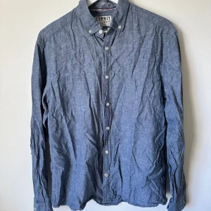 Blå linneskjorta från Esprit - Snygg blå skjorta från Esprit i regular fit. Skjortan är tillverkad i en mix av linne och bomull, har klassisk krage och vita knappar framtill. Perfekt för dig som gillar en stilren och avslappnad look. A339