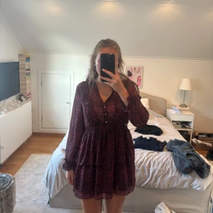 Röd leopardmönstrad klänning från Zara - Snygg kort klänning från Zara med rött och svart leopardmönster. Klänningen har långärmade transparenta ärmar med volangdetaljer vid mudden, v-ringad hals och knappar framtill. Använd 1 gång💕☺️