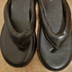 Svarta sandaler från Even&Odd - Chunky svarta sandaler från Even&Odd med breda remmar och platt sula. Tillverkade i syntetmaterial med minimalistisk design och rund tå. Perfekta för en chill sommarlook. Obs! Har använt bara en gång