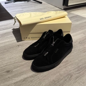 Axel Arigato skor - Axel Arigato Clean 90 zip i väldigt bra skick. Får med skolådan och oanvänd skopåse. Sparsamt andvända, säljer för att dem är för små. Skriv vid frågor. 