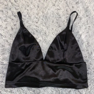 Svart satin bandeau topp - Snygg svart bandeau topp i glansigt satinliknande material med smala axelband💘Passar perfekt till en varm sommardag🙏
