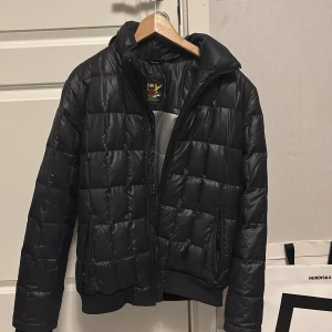 Svart pufferjacka från Zara Young - Snygg svart pufferjacka från Zara Young Collection med quiltad design och silvrigt foder. Obs! Läcker lite dun då och då men inte så mycket