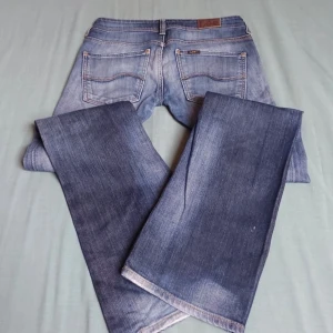 Blå bootcut jeans - Snygga blå bootcut jeans med en klassisk tvätt. De har en låg midja och är perfekta för en avslappnad stil. Jeansen har fem fickor och stängs med en dragkedja och knapp framtill. Midjemåttet är ca 38 cm och innerbenslängden 81